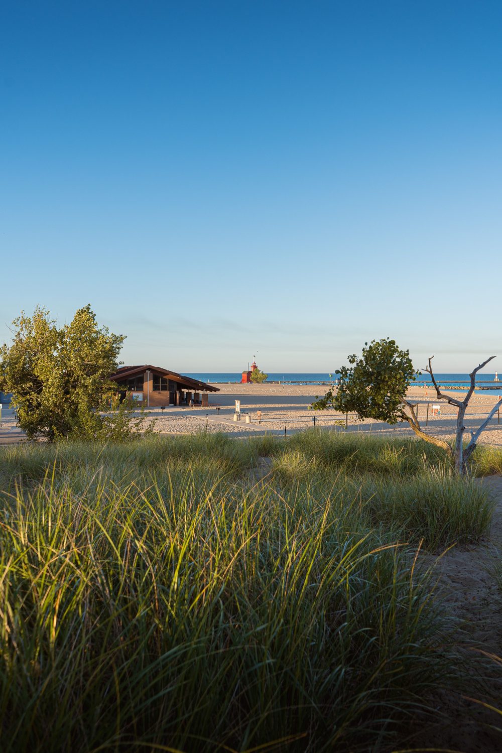 Lake Michigan beach with dune grass and lighthouse