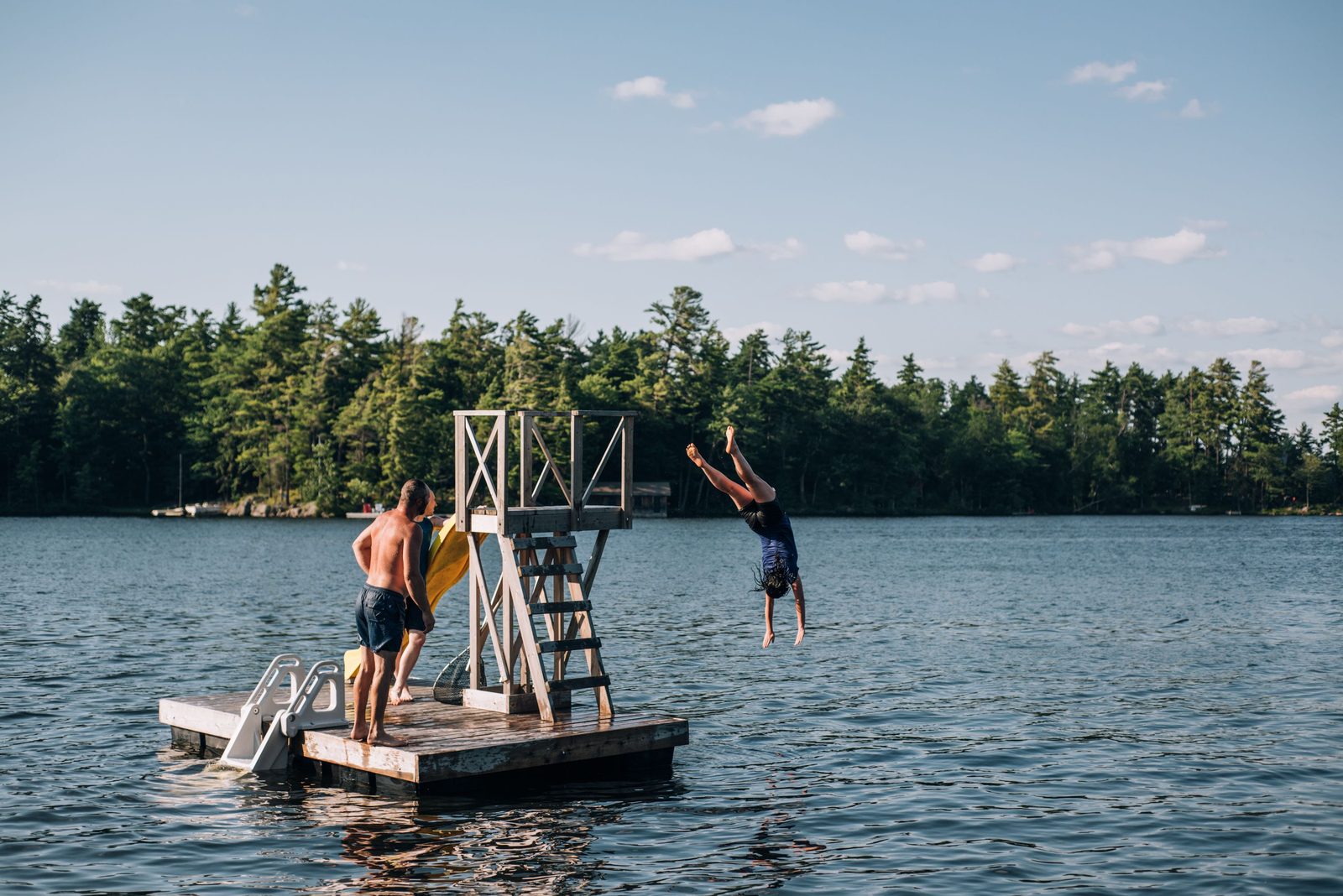 Family jumping off a dock into a Northern Michigan lake